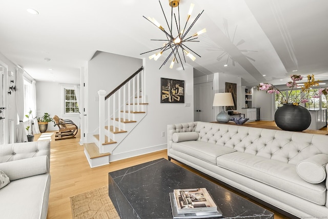living area featuring stairway, baseboards, a notable chandelier, light wood-style floors, and recessed lighting
