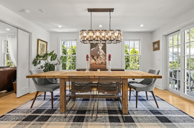 dining area featuring light wood-type flooring, recessed lighting, and a chandelier