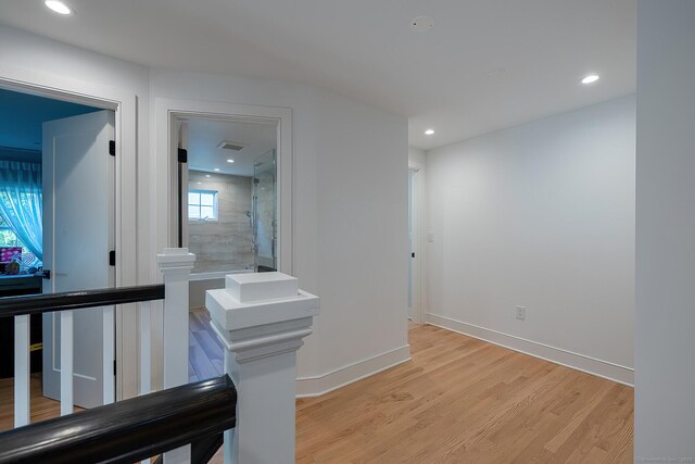 corridor featuring recessed lighting, baseboards, light wood-type flooring, and an upstairs landing