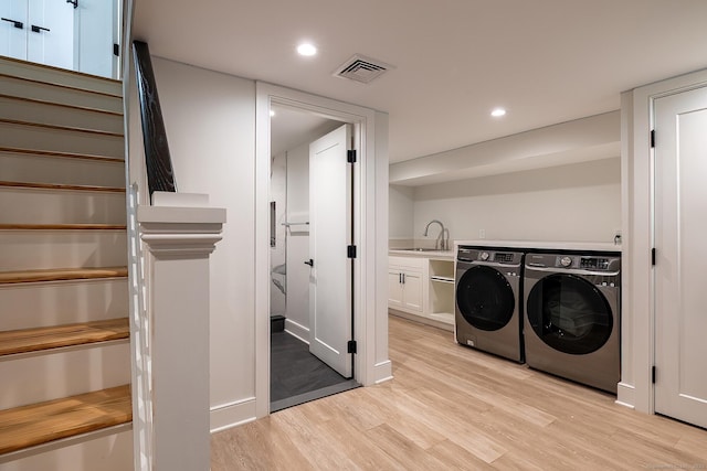 laundry room with visible vents, washing machine and clothes dryer, cabinet space, light wood finished floors, and recessed lighting