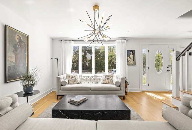 living room featuring baseboards, an inviting chandelier, a wealth of natural light, and wood finished floors