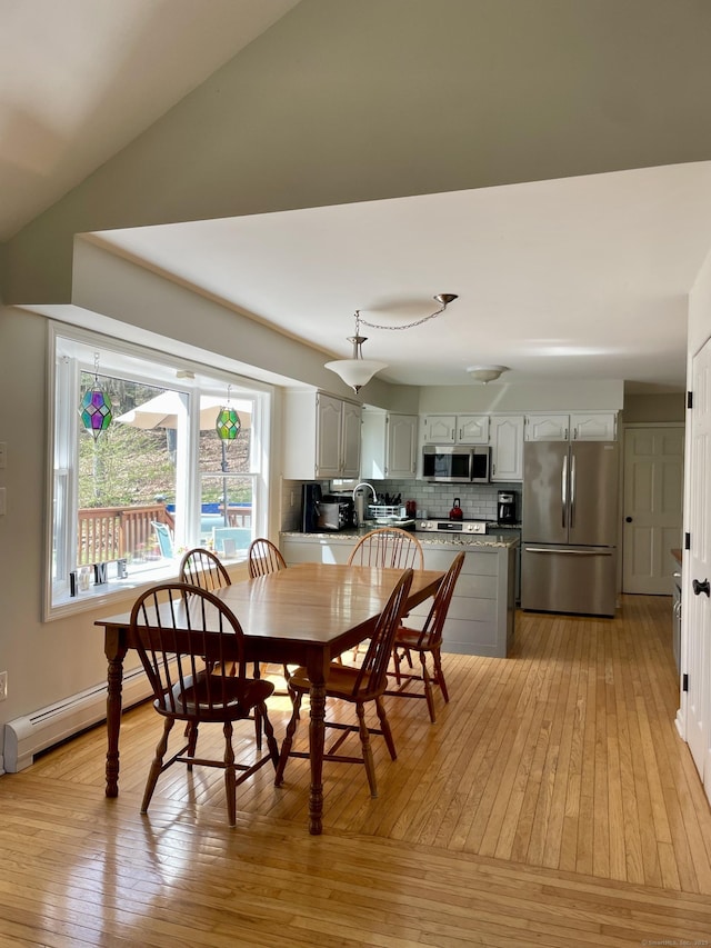 dining room with light wood finished floors and baseboard heating