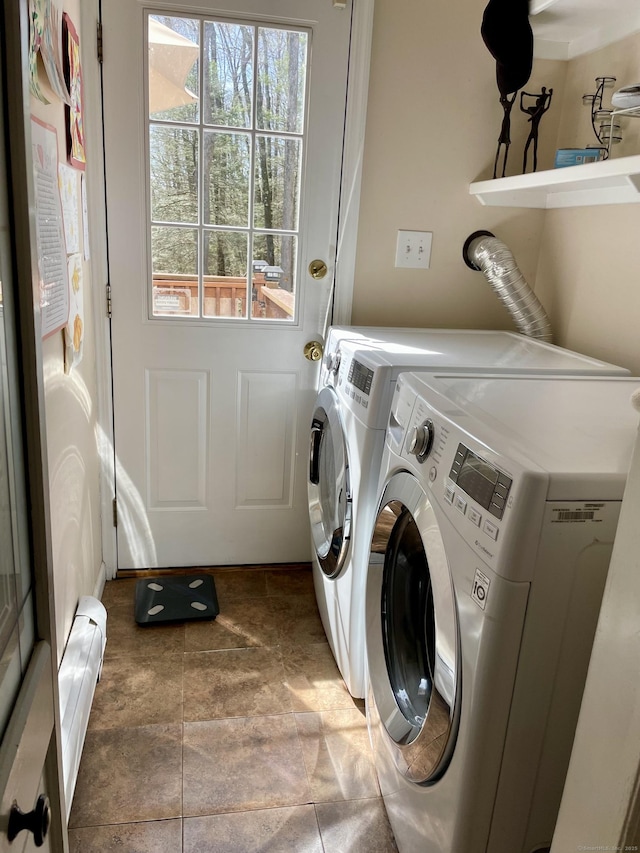 washroom with a wealth of natural light, washer and clothes dryer, and laundry area
