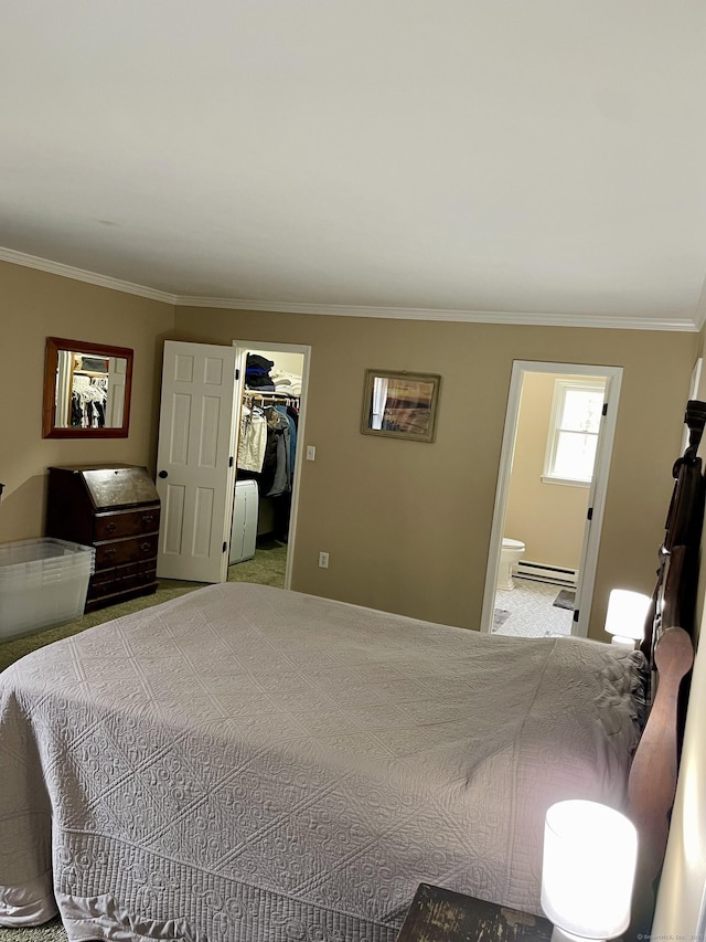 carpeted bedroom featuring connected bathroom, baseboard heating, a closet, ornamental molding, and a walk in closet