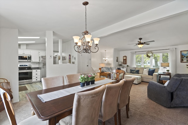 dining area with beam ceiling, light carpet, and ceiling fan with notable chandelier
