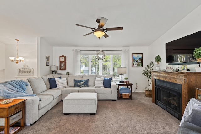 carpeted living room featuring a fireplace and ceiling fan with notable chandelier