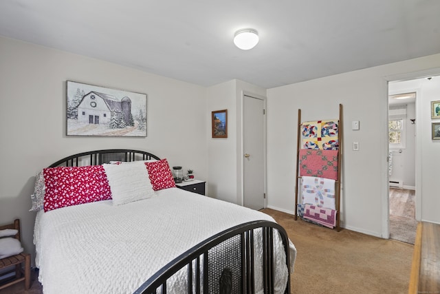 bedroom featuring a baseboard heating unit, carpet floors, and baseboards