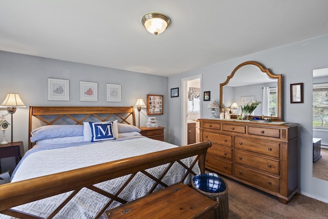 bedroom with ensuite bath and carpet floors