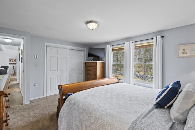 carpeted bedroom with baseboards and a closet