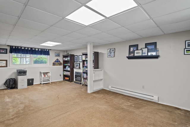 below grade area featuring baseboards, a drop ceiling, carpet, and a baseboard radiator