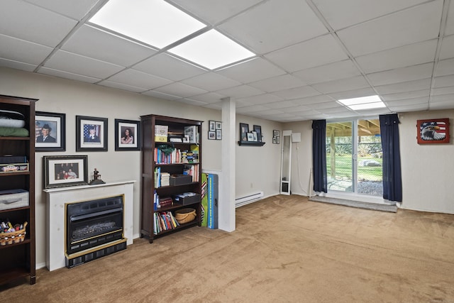 below grade area featuring a baseboard heating unit, a drop ceiling, and carpet floors