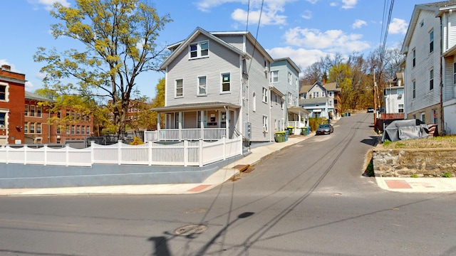 view of side of home featuring covered porch and a residential view