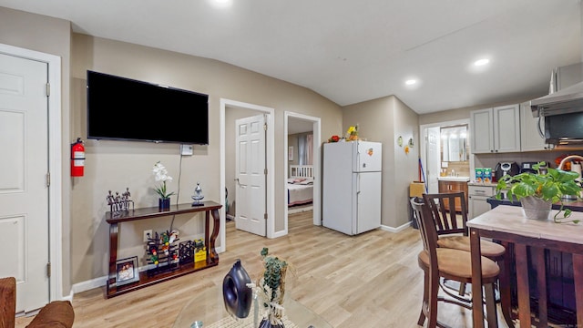 kitchen with light countertops, freestanding refrigerator, baseboards, recessed lighting, and light wood finished floors