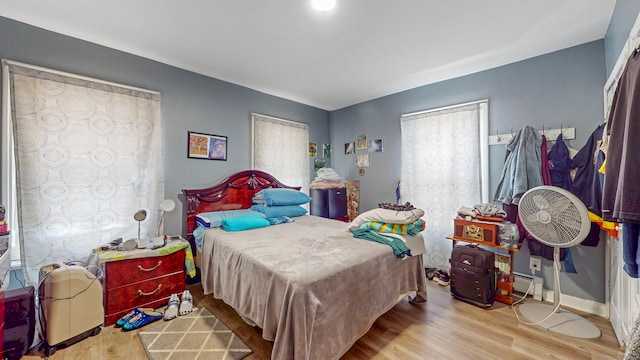 bedroom with baseboards and wood finished floors
