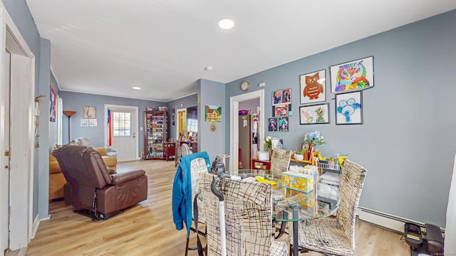 dining space featuring a baseboard radiator, recessed lighting, and light wood finished floors