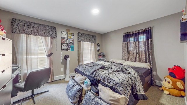 carpeted bedroom with baseboards and multiple windows