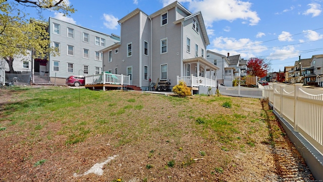 rear view of property featuring fence, a residential view, and a yard
