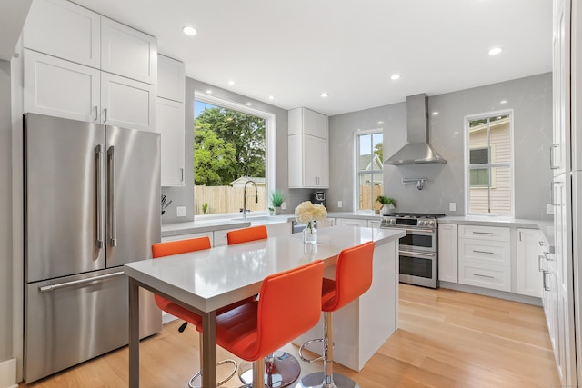 60 Eleanor Ter, Fairfield, CT 06824 - kitchen with appliances with stainless steel finishes, wall chimney range hood, light countertops, white cabinetry, and recessed lighting