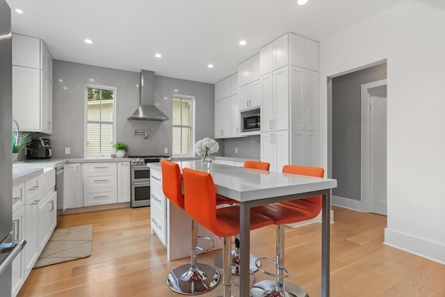 60 Eleanor Ter, Fairfield, CT 06824 - kitchen featuring stainless steel appliances, wall chimney exhaust hood, recessed lighting, white cabinetry, and light countertops