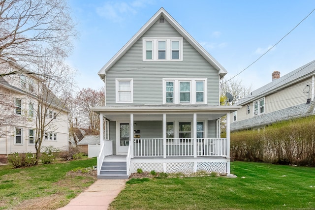 american foursquare style home with a porch and a front yard
