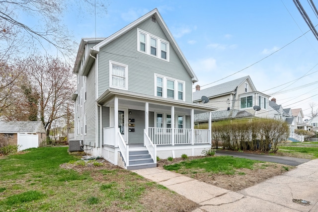 american foursquare style home with central AC, a porch, and a front yard