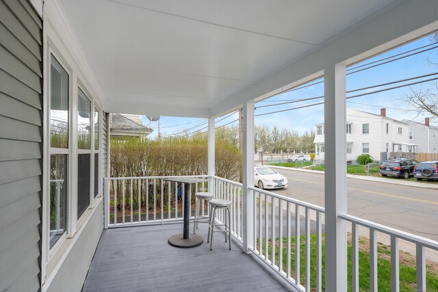 wooden deck with a residential view and covered porch