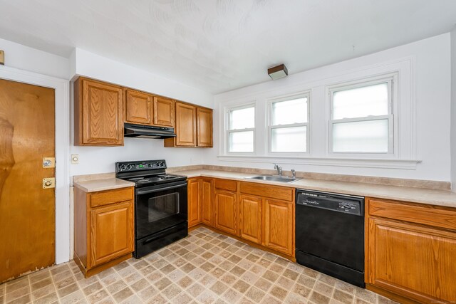 kitchen with black appliances, under cabinet range hood, a sink, and light countertops