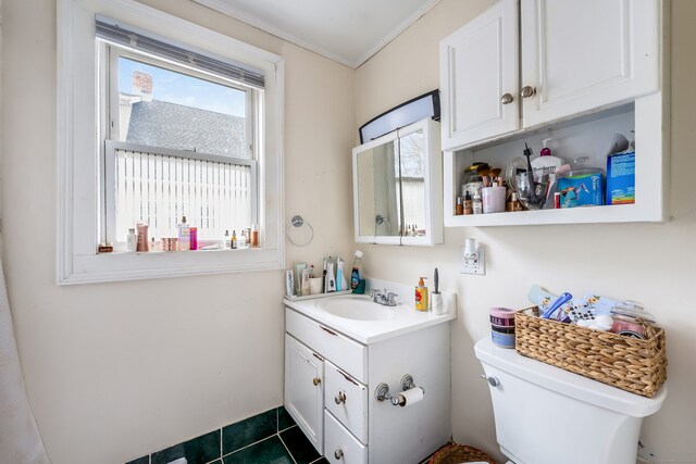 half bathroom with tile patterned flooring, toilet, vanity, and ornamental molding