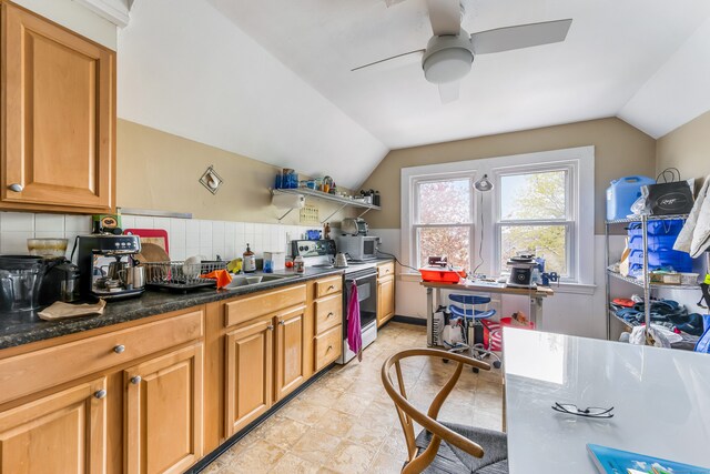 kitchen with stainless steel microwave, vaulted ceiling, a ceiling fan, and electric stove