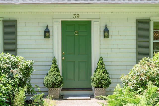 property entrance featuring roof with shingles