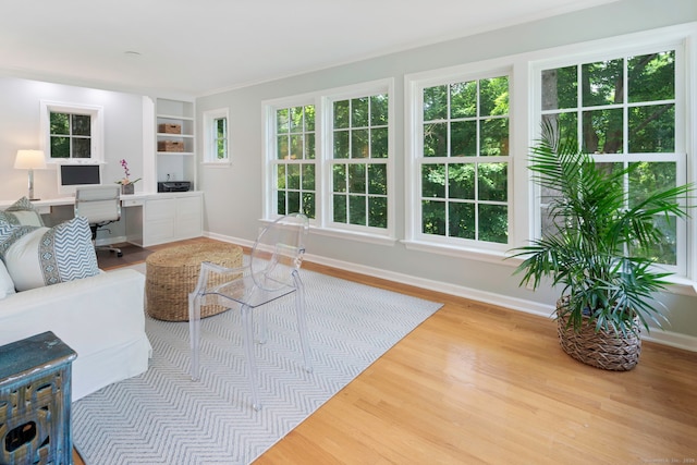 living area with plenty of natural light, wood finished floors, and baseboards
