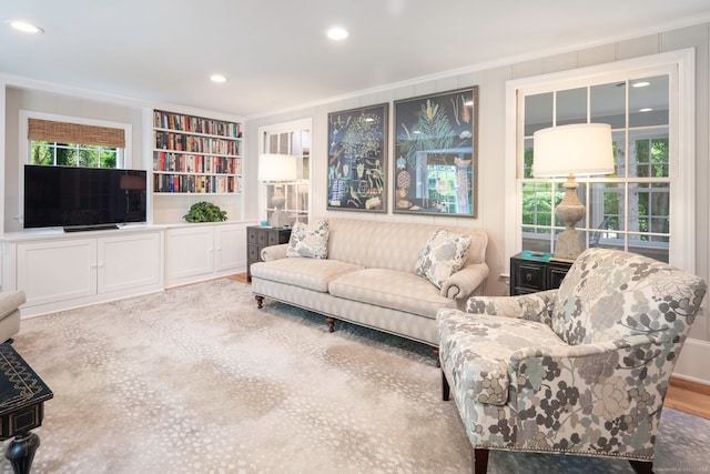 living room featuring recessed lighting, ornamental molding, and built in shelves