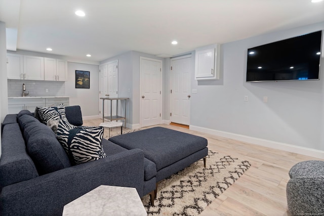 living room with light wood-type flooring, recessed lighting, and baseboards
