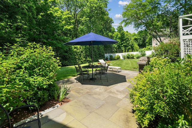 view of patio featuring area for grilling, outdoor dining area, and fence