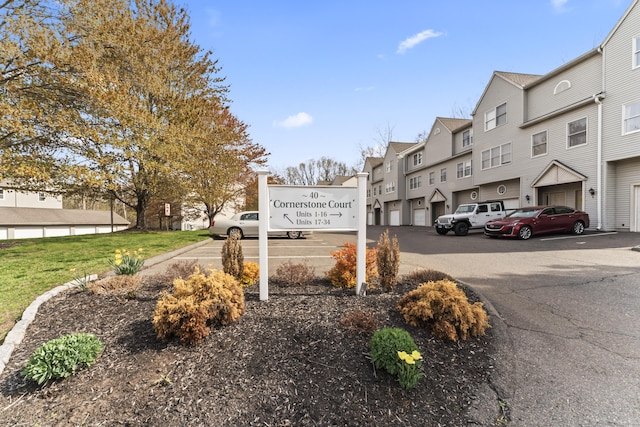 community sign with a residential view and uncovered parking