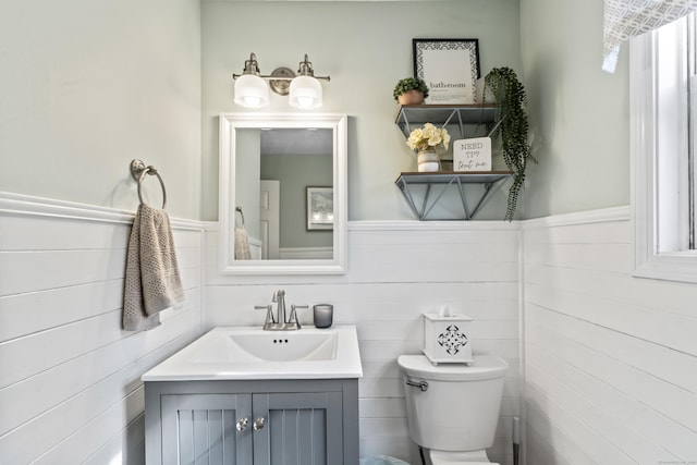 bathroom with wainscoting, toilet, and vanity
