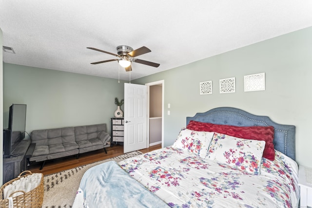 bedroom featuring wood finished floors, ceiling fan, and visible vents