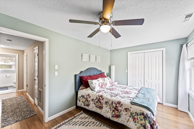 bedroom featuring visible vents, wood finished floors, a textured ceiling, and a closet