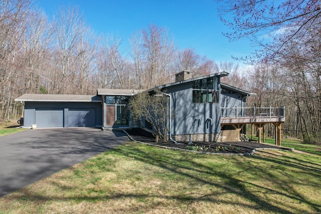 187 Sherbrook Dr, Goshen, CT 06756 - view of front of home featuring a deck, aphalt driveway, a front lawn, and an attached garage