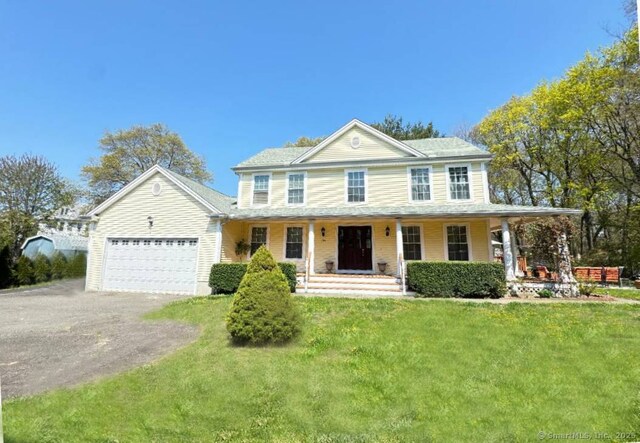 598 Nichols Ave, Stratford, CT 06614 - colonial-style house featuring covered porch, an attached garage, a front lawn, and aphalt driveway