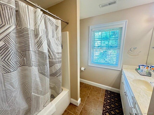 598 Nichols Ave, Stratford, CT 06614 - bathroom featuring vanity, tile patterned floors, shower / bath combination with curtain, baseboards, and visible vents