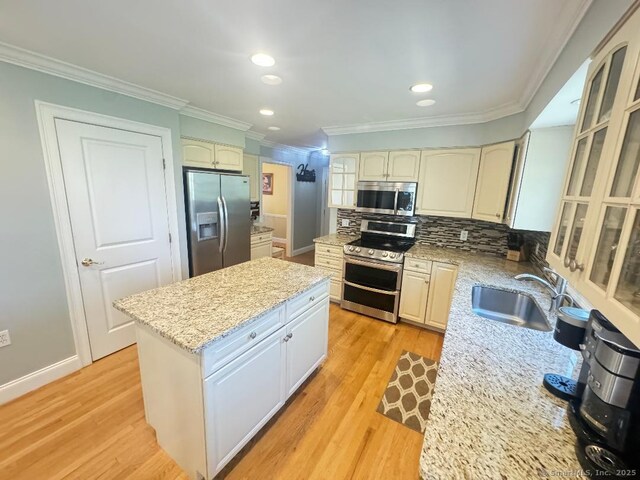 598 Nichols Ave, Stratford, CT 06614 - kitchen featuring a sink, appliances with stainless steel finishes, crown molding, and a kitchen island