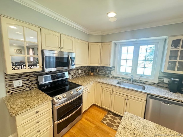 598 Nichols Ave, Stratford, CT 06614 - kitchen featuring ornamental molding, cream cabinets, tasteful backsplash, a sink, and stainless steel appliances