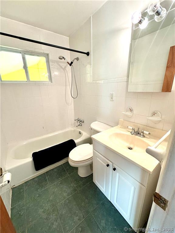 35 Marjorie Dr, North Branford, CT 06471 - bathroom with toilet, tile walls, washtub / shower combination, and vanity