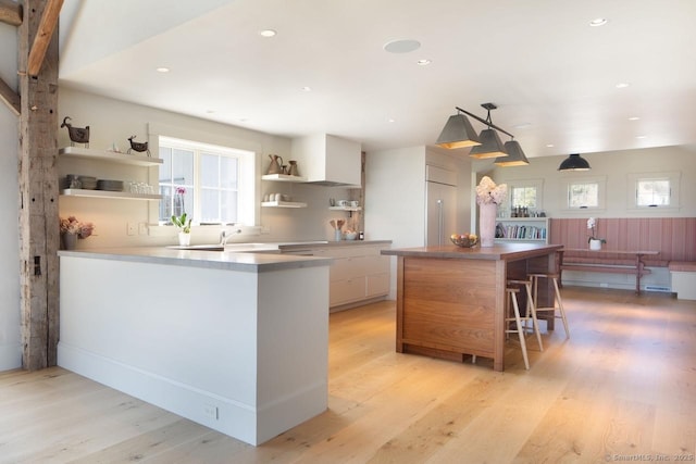 kitchen featuring built in refrigerator, open shelves, light wood-style flooring, white cabinets, and modern cabinets