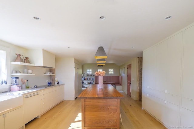 kitchen featuring light wood-type flooring, open shelves, butcher block countertops, and a kitchen island