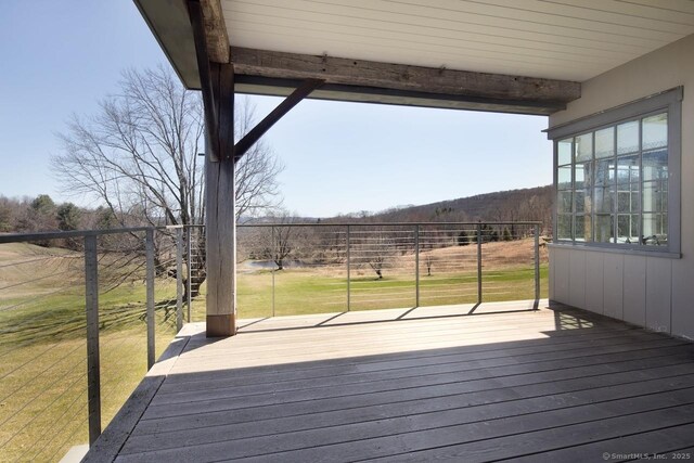wooden terrace with a lawn and fence
