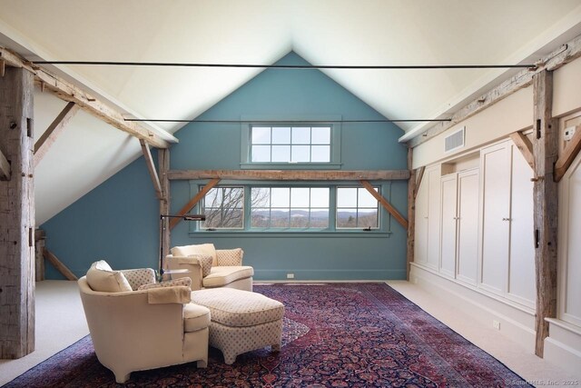 living area featuring visible vents, high vaulted ceiling, and carpet