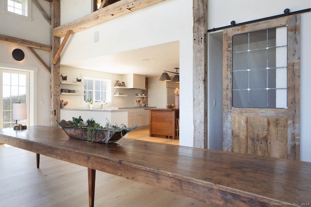 interior space with a high ceiling, a wealth of natural light, and a barn door