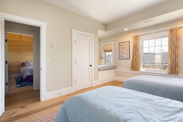bedroom with visible vents, baseboards, and light wood-type flooring